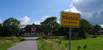 Ortsschild Klixbüll vor Gebäude