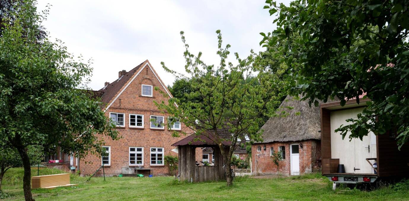 Backsteinhaus mit Garten und Bäumen