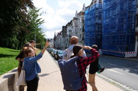 Leute betrachten Gebäude, Straßenszene bei Sonnenschein.