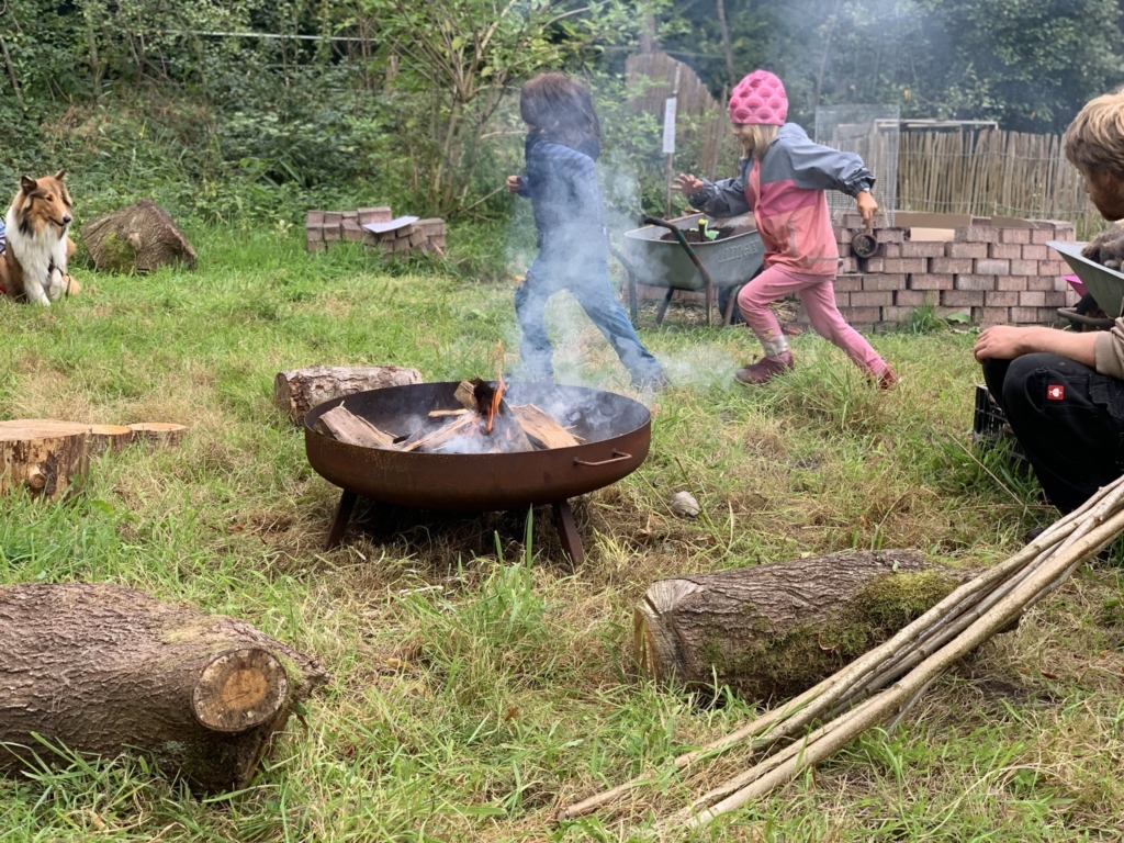 Kinder laufen um Lagerfeuer